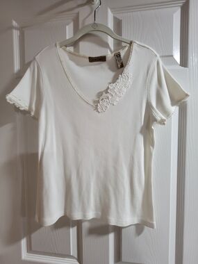 Cute white V-neck top. Has pretty lace trim around the neckline-size M